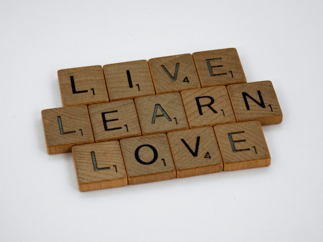 tan scrabble tiles on a white background that say listen, learn, love