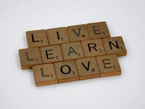 tan scrabble tiles on a white background that say listen, learn, love