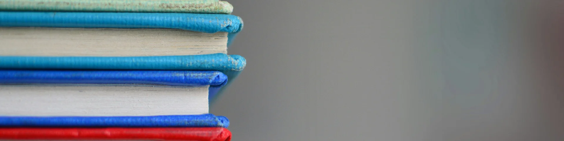 colorful books stacked on the left against a gray background