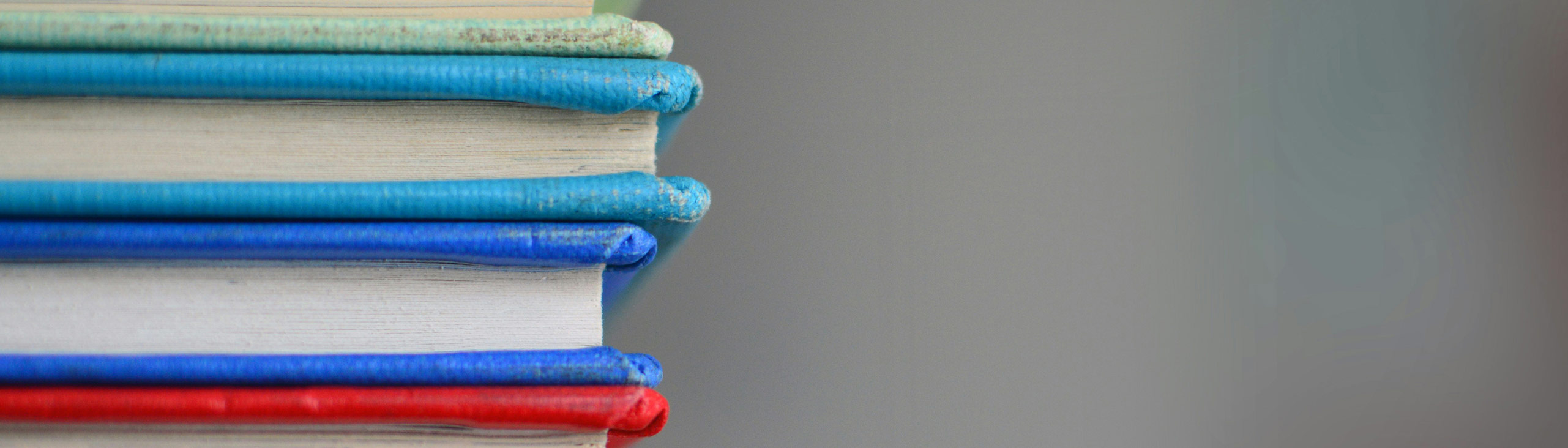 colorful books stacked on the left against a gray background