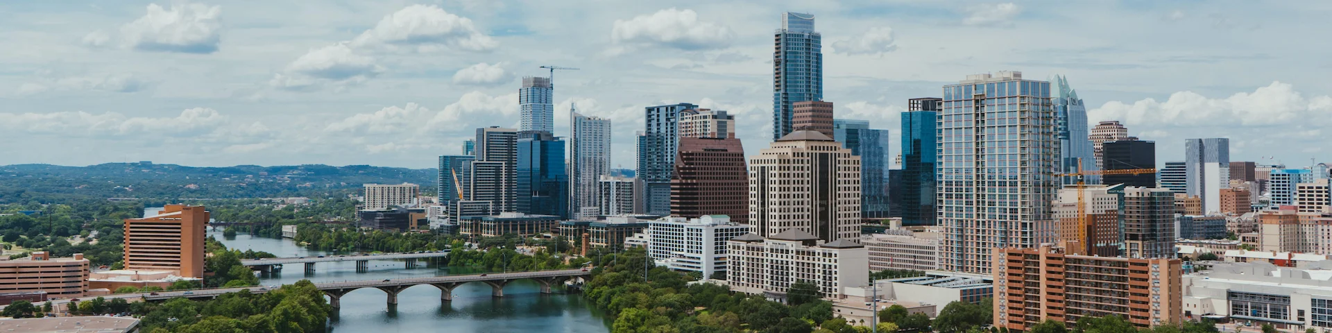 skyline of Austin, TX including skyscrapers, a river, and a bridge